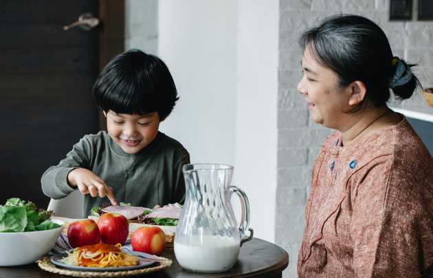 Grandmother serving breakfast to grandson